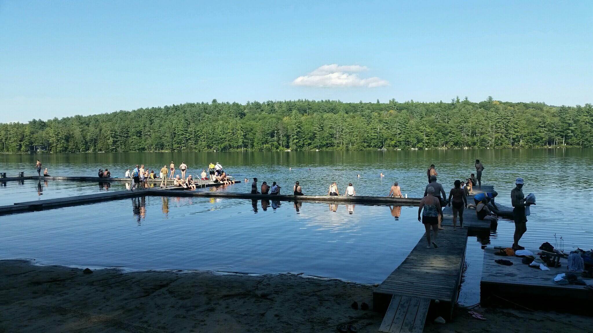 Bike Maine members sitting on a dock and swimming