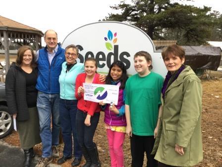 NSB employees present donation check to Seeds of Independence founders and a few students
