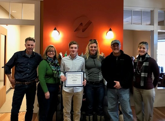 Group of people standing. One person holding award