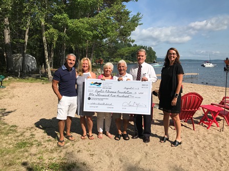 Group of people presenting check on beach