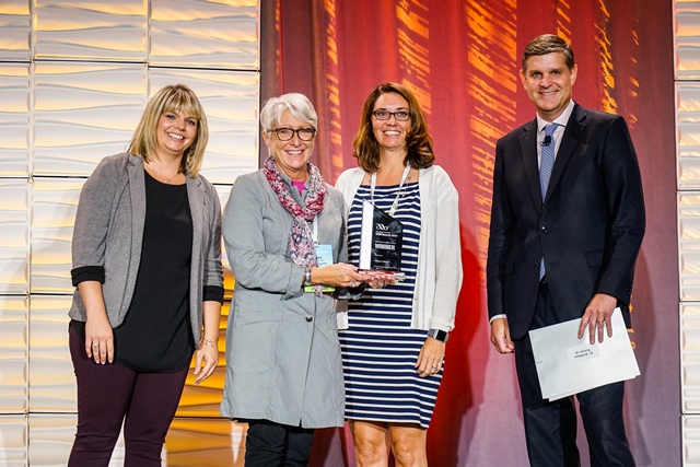 Group of people holding award.