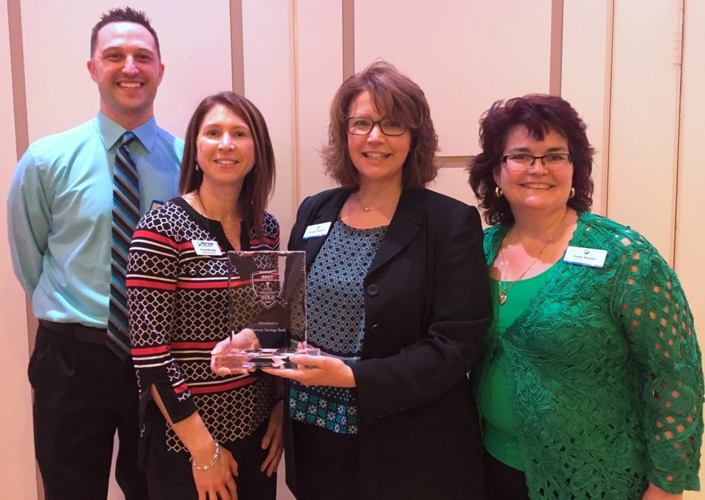 four people holding an award