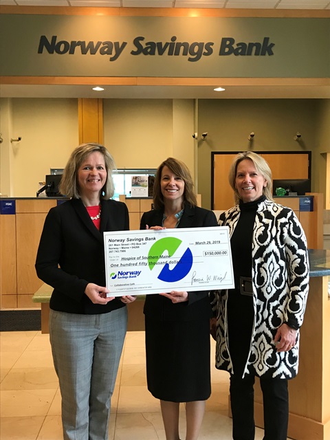 Three women with large check
