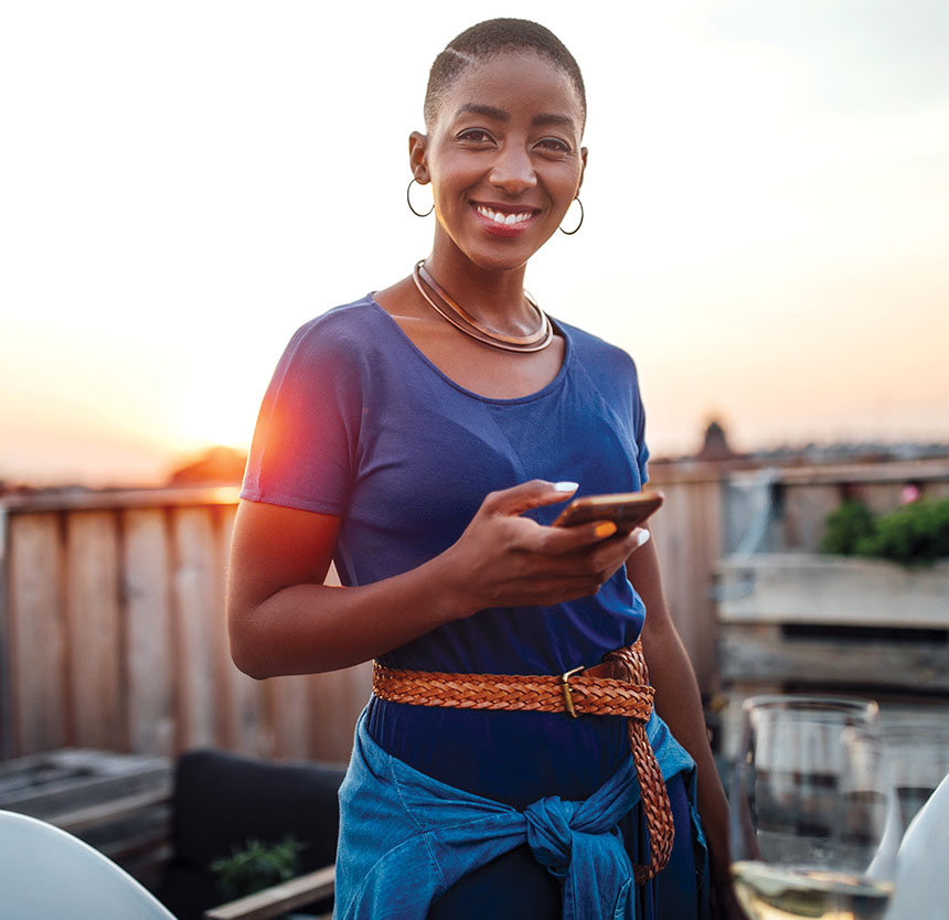 woman smiling and carrying a smartphone looking at Norway Savings careers