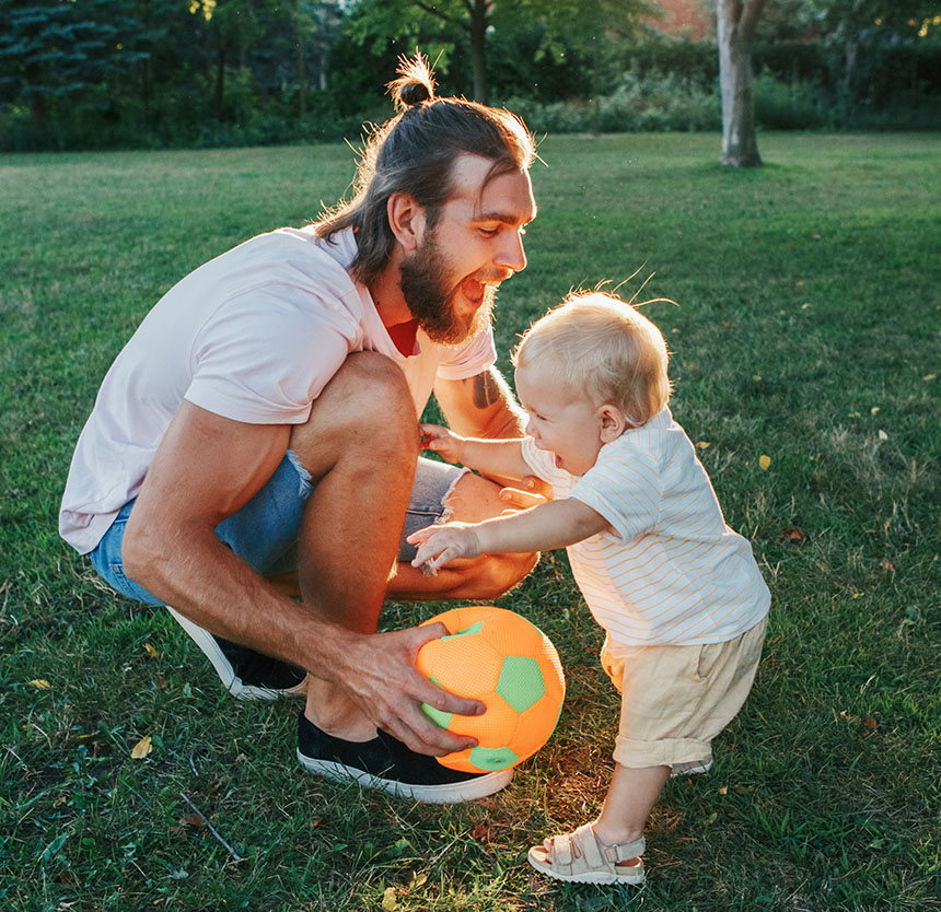 young father playing with toddler and happy because he has free solutions checking at Norway Savings