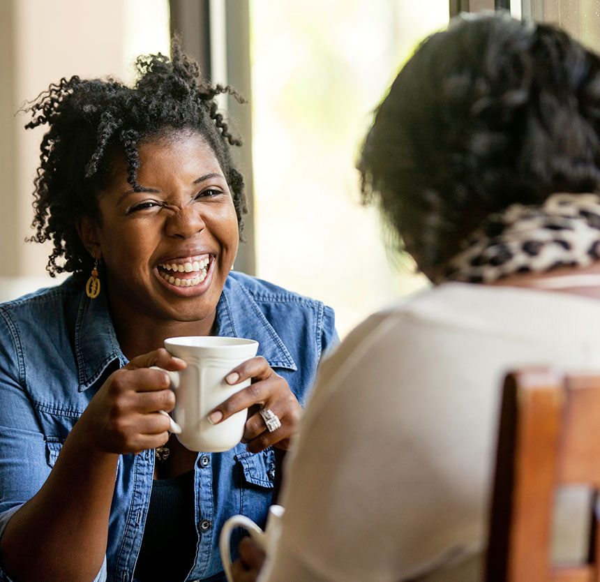 Woman out for coffee with a friend and happy she has full solutions checking at norway savings