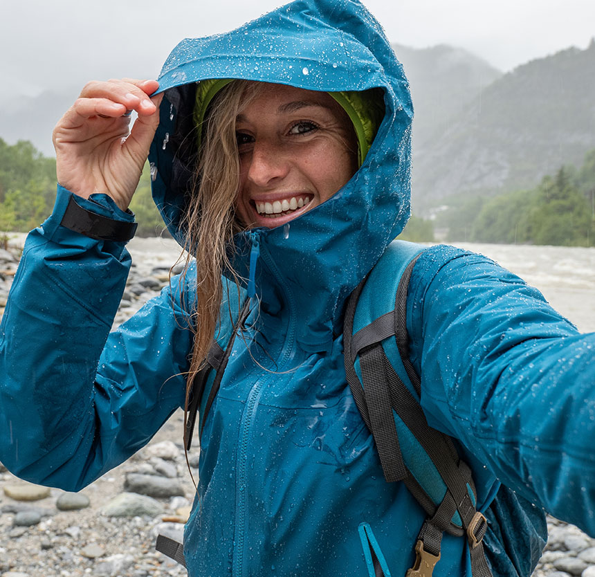 woman smiling in the rain on a mountain
