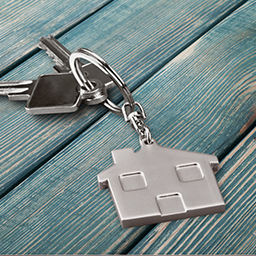 Keys on a keychain with a dangling silver house